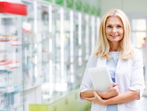 cheerful-pharmacist-holding-digital-tablet-and-smi-98L5GF6-1-min